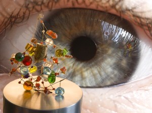 Photo of close up of an eye staring at a small sculpture made of coloured glass beads.