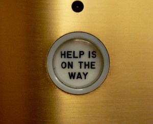 Photo of lift button with 'Help Is On Its Way' written on the button.